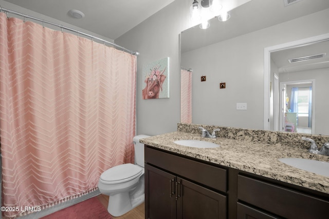 full bath with double vanity, toilet, a sink, and a shower with shower curtain