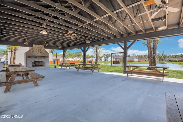 view of patio / terrace with a water view and an outdoor stone fireplace