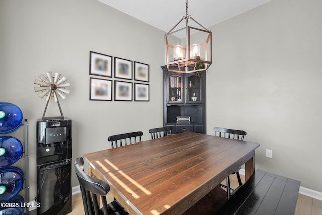 dining space featuring baseboards and a chandelier