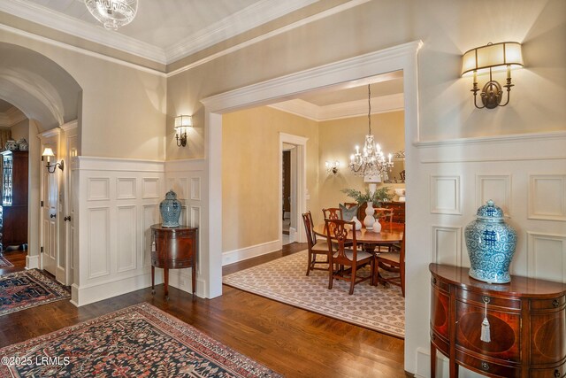 interior space with dark hardwood / wood-style flooring, ornamental molding, and an inviting chandelier