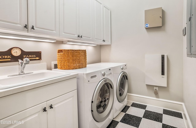 laundry area featuring cabinets, electric panel, sink, and washer and dryer