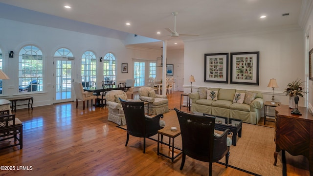 living room with ornamental molding, ceiling fan, and light hardwood / wood-style flooring