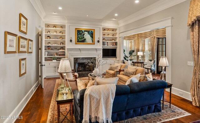 living room featuring built in shelves, ornamental molding, a high end fireplace, and dark hardwood / wood-style floors