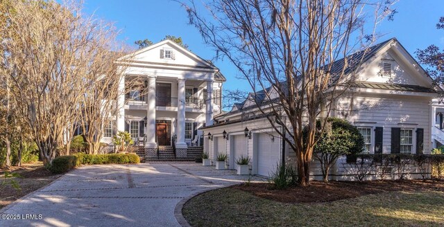 greek revival inspired property featuring a garage