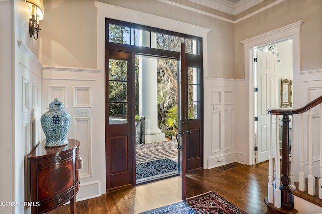 entryway featuring ornamental molding and dark hardwood / wood-style floors