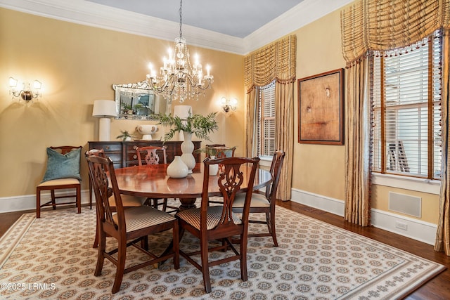 dining area featuring ornamental molding, wood-type flooring, and an inviting chandelier