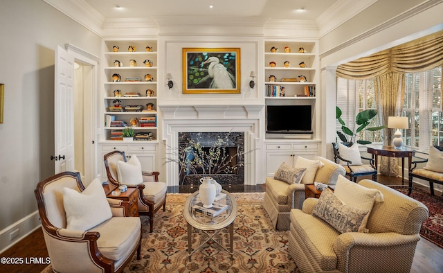 sitting room with built in shelves, a high end fireplace, ornamental molding, and dark hardwood / wood-style floors