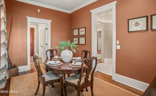 dining room with ornamental molding and light wood-type flooring