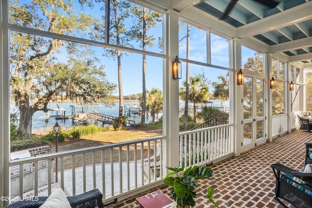 sunroom featuring a wealth of natural light and a water view