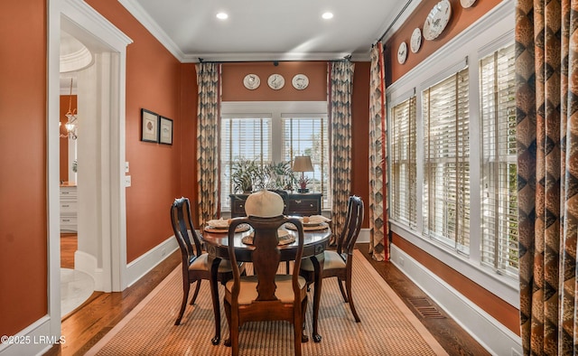 dining area with wood-type flooring and crown molding