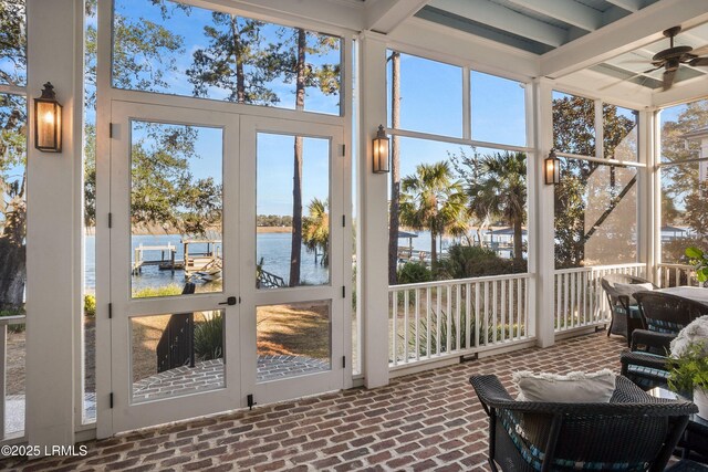 sunroom featuring a water view and ceiling fan