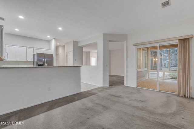 unfurnished living room featuring light carpet