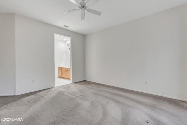 spare room featuring light colored carpet and ceiling fan