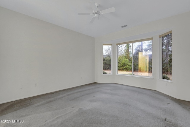 carpeted spare room featuring ceiling fan