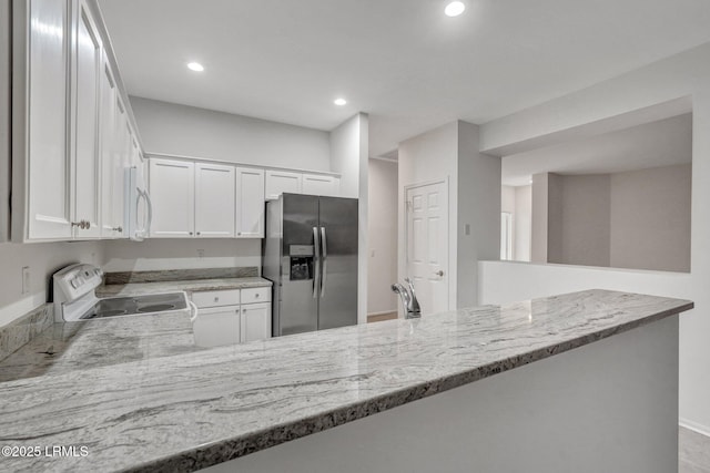 kitchen with white cabinetry, light stone countertops, white appliances, and kitchen peninsula