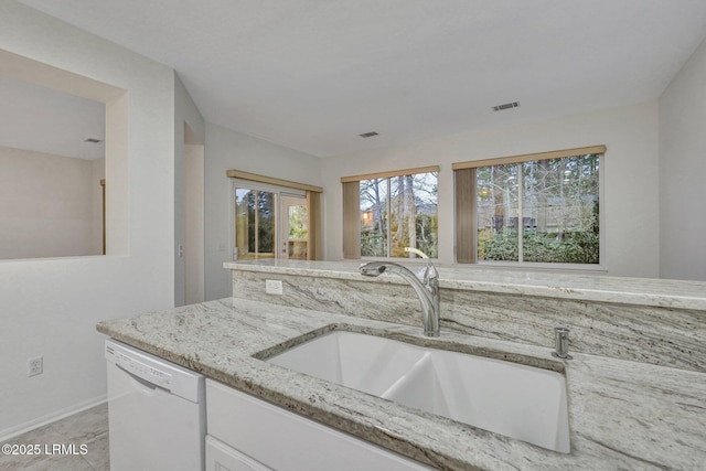 kitchen featuring light stone counters, sink, white cabinets, and dishwasher