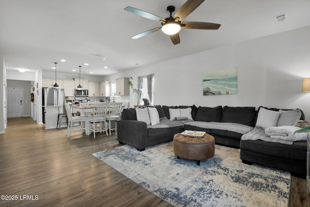 living room featuring dark hardwood / wood-style floors and ceiling fan