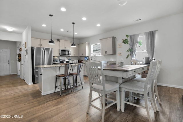 dining space with wood-type flooring and sink