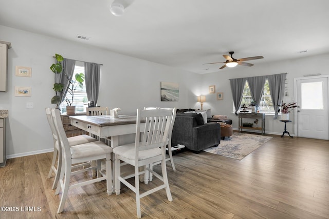 dining space with ceiling fan and light hardwood / wood-style floors