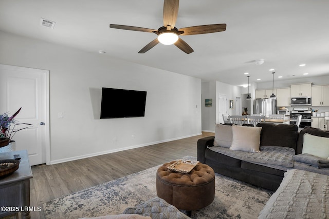 living room featuring hardwood / wood-style floors and ceiling fan