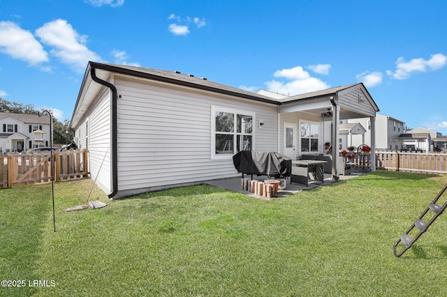 rear view of property with a lawn and a patio