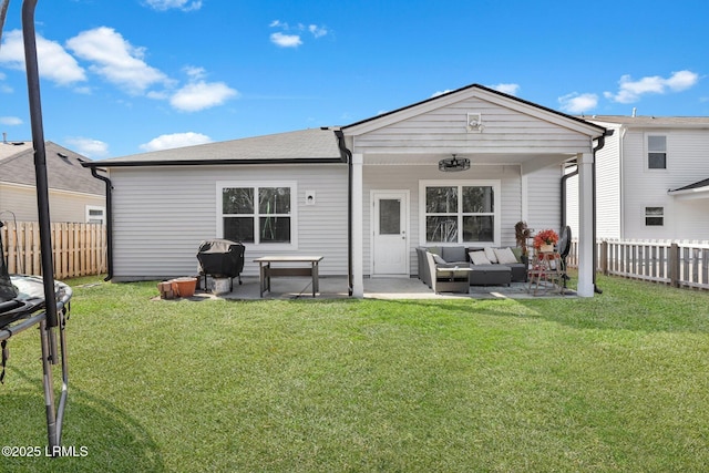 back of property featuring outdoor lounge area, a trampoline, a patio area, and a lawn