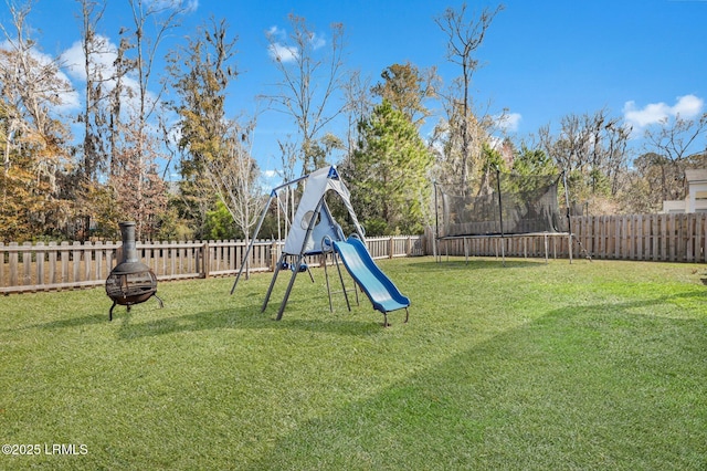 view of yard with a playground, a fire pit, and a trampoline