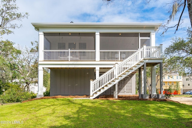 rear view of house with a yard and a sunroom