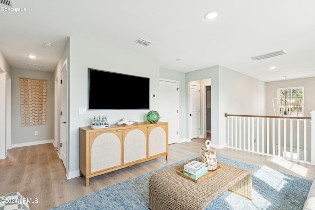 living room with an inviting chandelier and light hardwood / wood-style floors