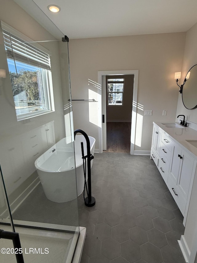 bathroom with vanity, a bathtub, and a healthy amount of sunlight