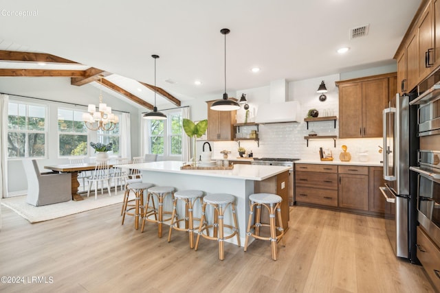 kitchen with pendant lighting, an island with sink, vaulted ceiling with beams, backsplash, and custom range hood