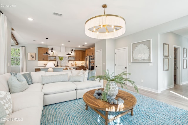 living room featuring light hardwood / wood-style floors and a notable chandelier