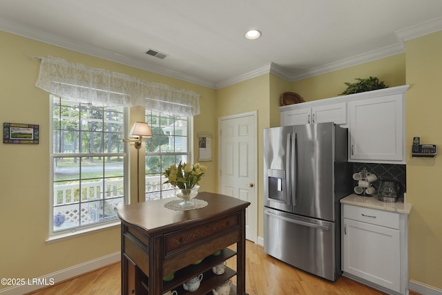 11 Argent Way, Bluffton, SC 29909 - kitchen with stainless steel fridge with ice dispenser, plenty of natural light, white cabinetry, tasteful backsplash, and ornamental molding