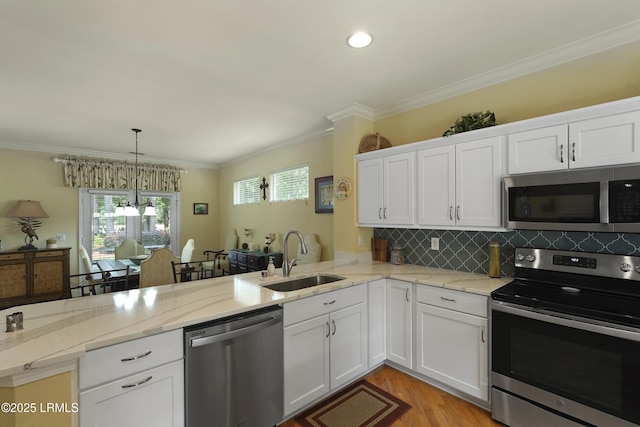 11 Argent Way, Bluffton, SC 29909 - kitchen with appliances with stainless steel finishes, a sink, a peninsula, white cabinets, and light wood-style floors