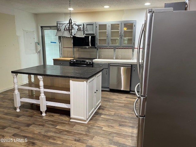 24 James F Byrnes St, Ladys Island, SC 29907 - kitchen featuring appliances with stainless steel finishes, decorative backsplash, dark wood-style floors, recessed lighting, and glass insert cabinets