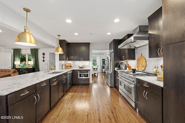 17 Audubon Rd, Ladys Island, SC 29907 - kitchen featuring a peninsula, wall chimney exhaust hood, appliances with stainless steel finishes, dark brown cabinets, and backsplash