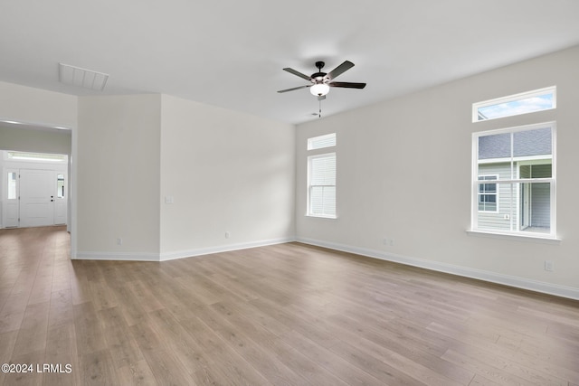 spare room with light hardwood / wood-style flooring, ceiling fan, and plenty of natural light