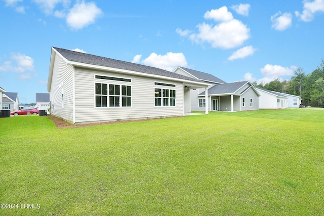 rear view of property with a yard and central AC unit