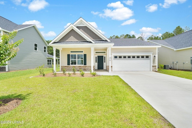 craftsman-style home featuring a garage, covered porch, a front yard, and central air condition unit