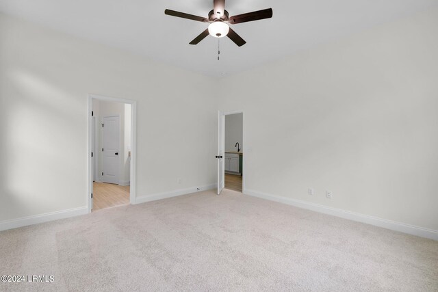 unfurnished room with light colored carpet and ceiling fan