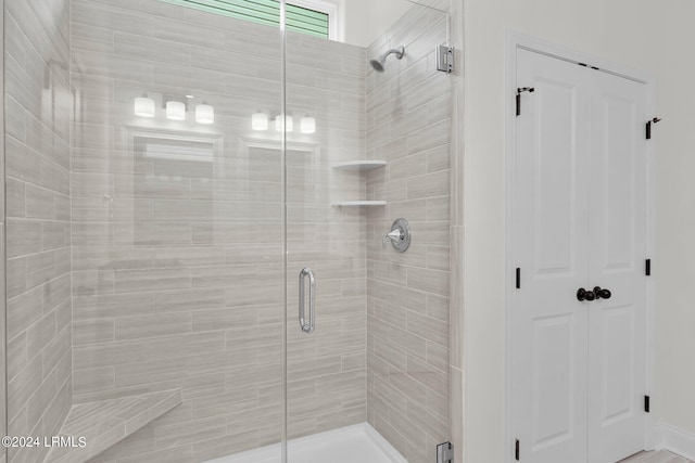 bathroom featuring a shower with door