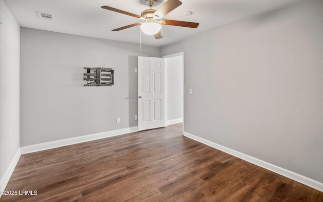 empty room with dark wood-type flooring and ceiling fan