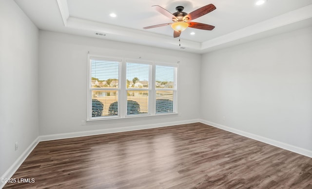 unfurnished room featuring dark hardwood / wood-style flooring and a tray ceiling