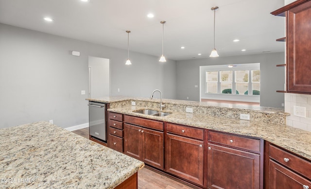 kitchen featuring tasteful backsplash, sink, pendant lighting, and light hardwood / wood-style flooring