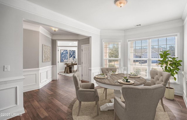 dining space featuring dark hardwood / wood-style flooring and crown molding