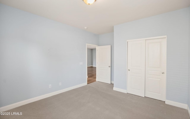 unfurnished bedroom featuring light carpet and a closet