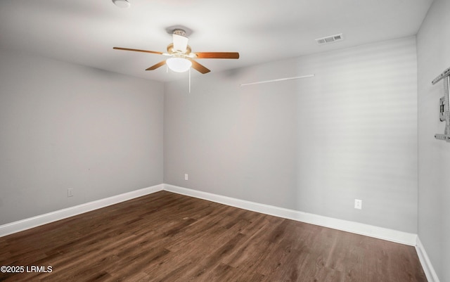 spare room featuring dark hardwood / wood-style flooring and ceiling fan