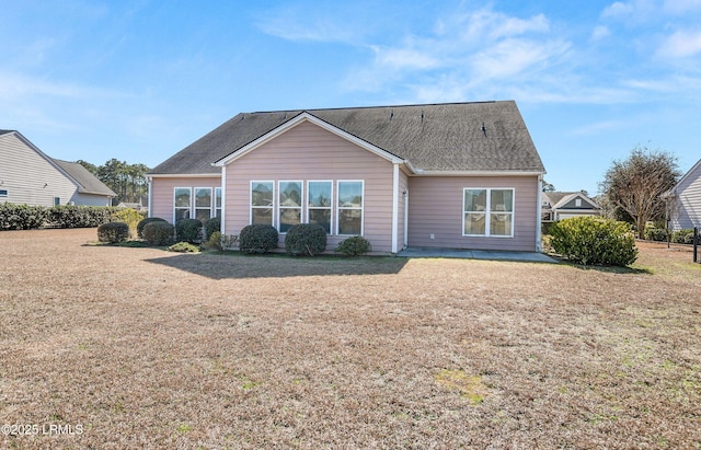 rear view of property featuring a lawn