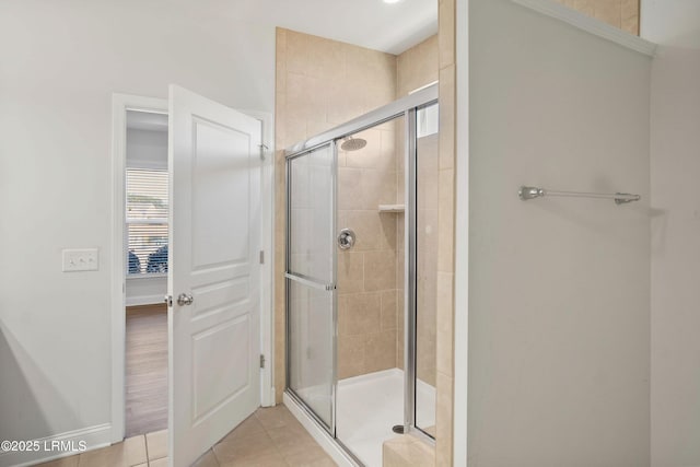 bathroom with a shower with door and tile patterned floors