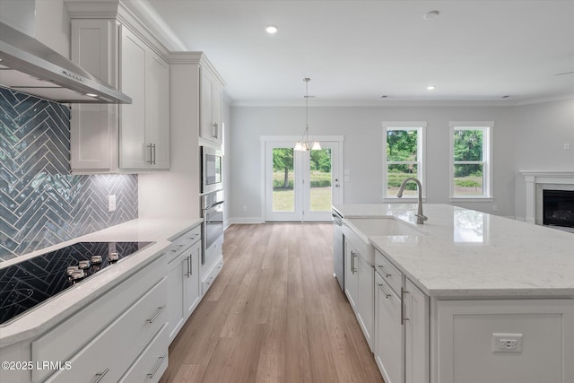 41 Fairfield Rd, Beaufort, SC 29907 - kitchen featuring backsplash, light wood-type flooring, a sink, stainless steel appliances, and wall chimney exhaust hood
